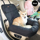 Corgi sitting in a dog car seat bed in black next to a woman driving