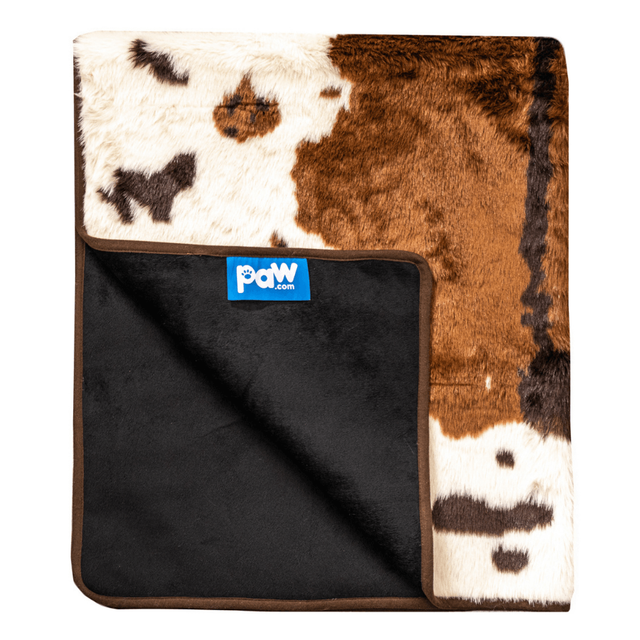 Cow print blanket with black backing and a visible brand logo on a white background