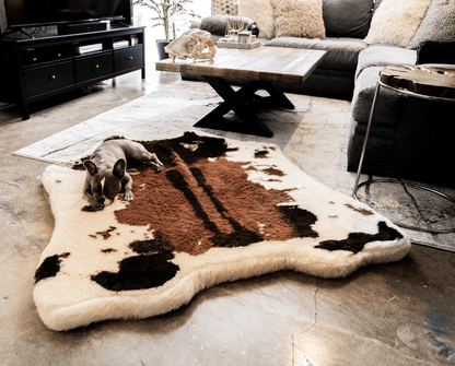 Cow print rug in a living room with a dog lying on it
