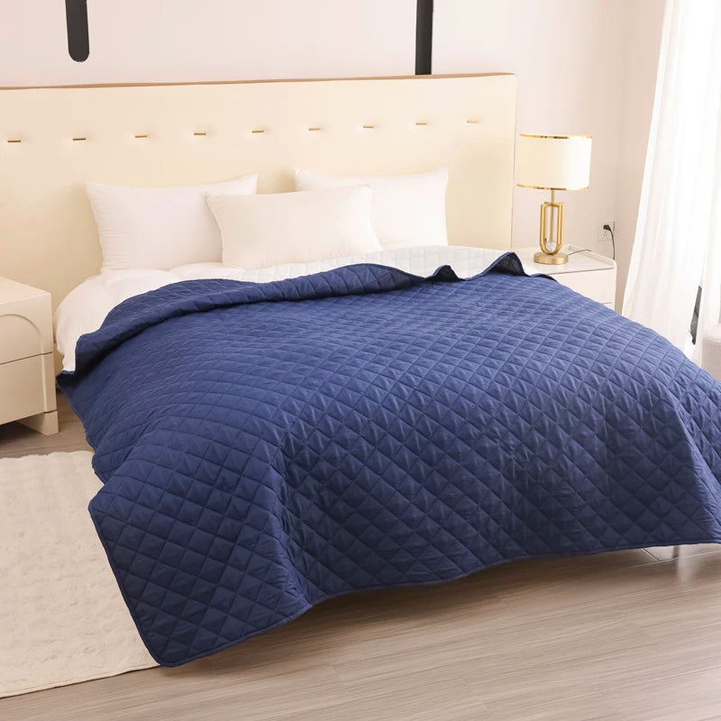 Blue quilted cover on a bed in a bedroom setting