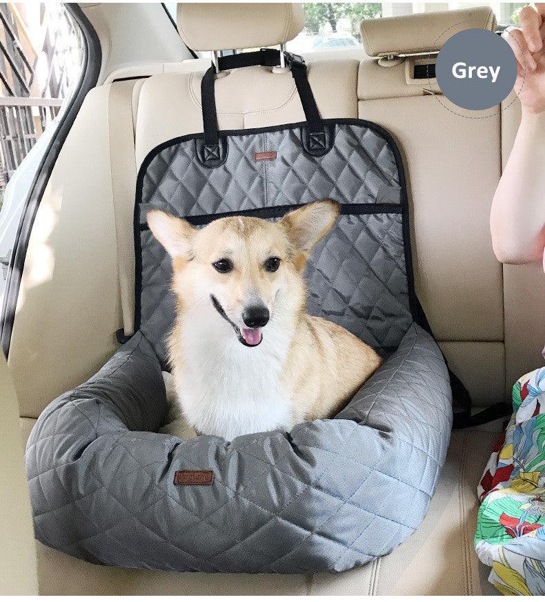 Corgi sitting in a dog car seat bed in grey