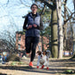 Dog running with woman and wearing Pawz small size dog boots in red